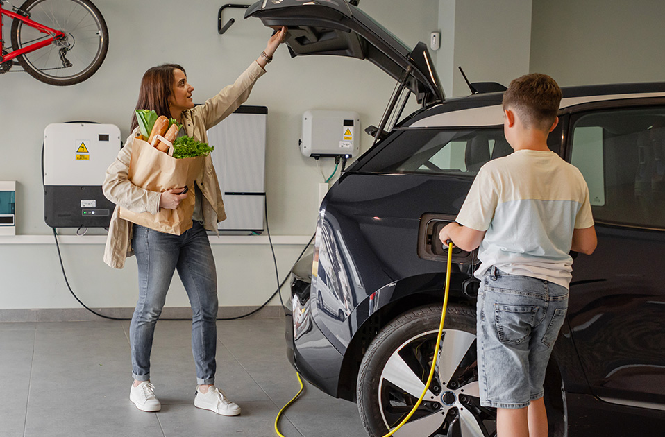 kid plugging his mom's ev at home